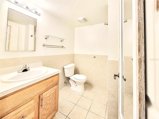 bathroom with tile patterned floors, toilet, wainscoting, visible vents, and vanity
