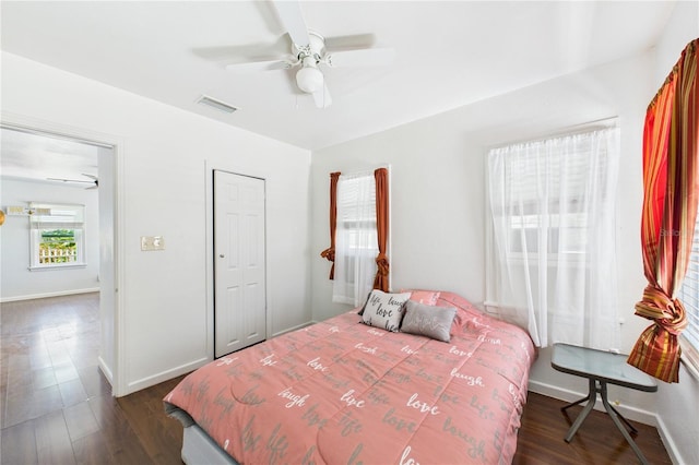 bedroom with dark wood-style flooring, visible vents, ceiling fan, and baseboards