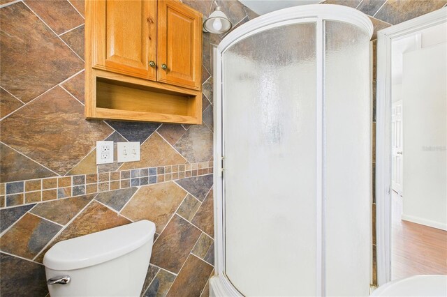 bathroom with a shower stall and toilet