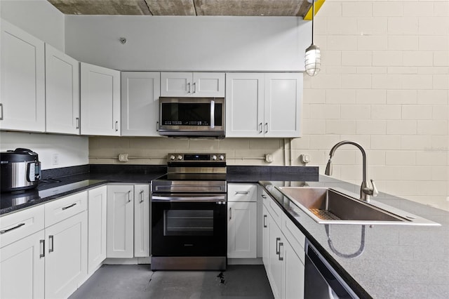 2515 SW 35th Pl Unit 203, Gainesville, FL 32608 - kitchen with appliances with stainless steel finishes, concrete flooring, and white cabinets