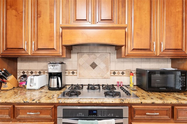 4714 NW 19th Pl, Gainesville, FL 32605 - kitchen with oven, black microwave, gas cooktop, premium range hood, and backsplash