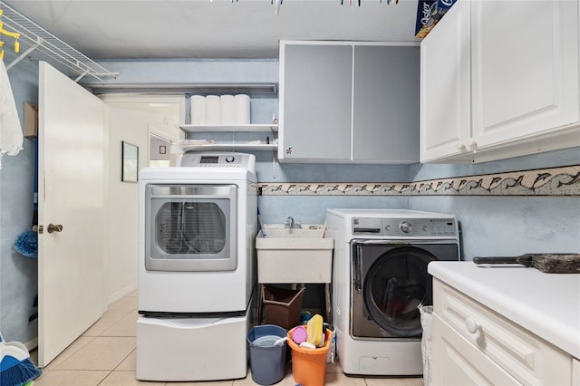 4714 NW 19th Pl, Gainesville, FL 32605 - laundry area featuring cabinet space, light tile patterned floors, a sink, and washer and clothes dryer
