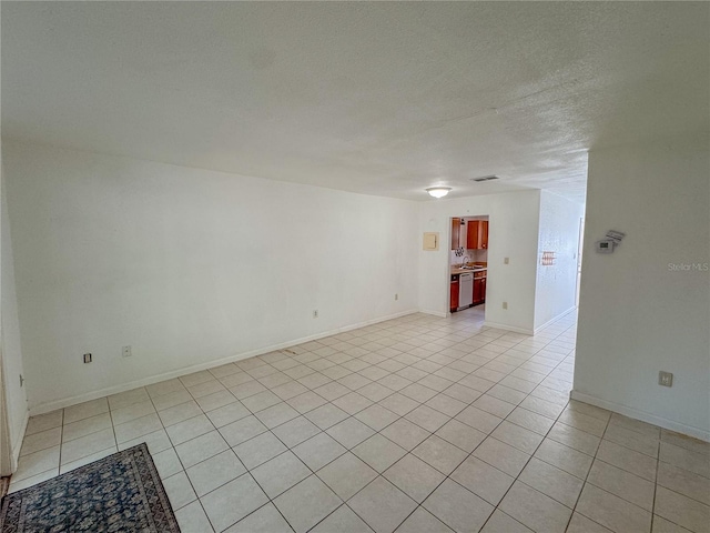 3935 SW 26th Ter Unit 3935A, Gainesville, FL 32608 - unfurnished room with baseboards, a textured ceiling, and light tile patterned floors