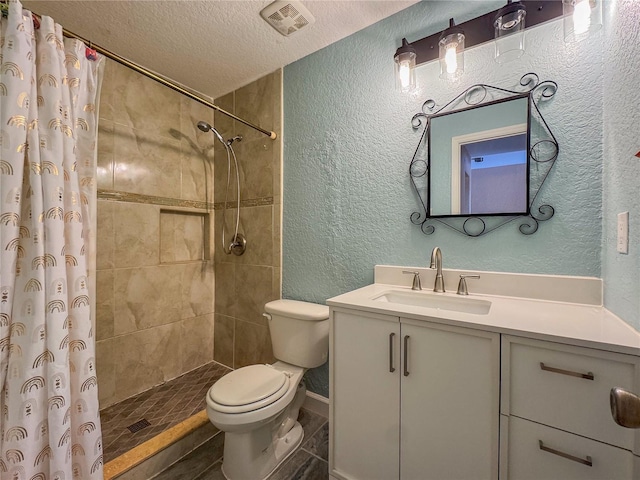 3935 SW 26th Ter Unit 3935A, Gainesville, FL 32608 - bathroom featuring vanity, a textured wall, toilet, tiled shower, and a textured ceiling
