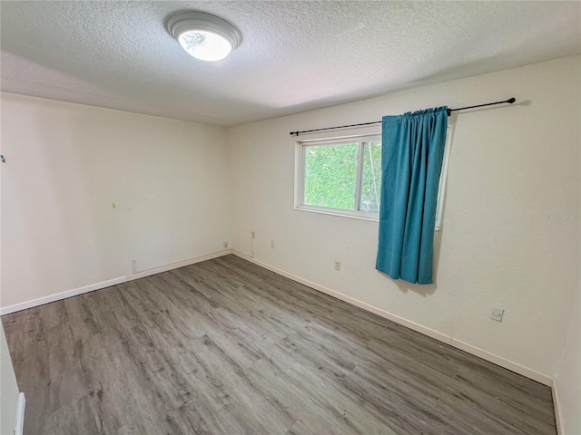 3935 SW 26th Ter Unit 3935A, Gainesville, FL 32608 - unfurnished room featuring baseboards, a textured ceiling, and wood finished floors