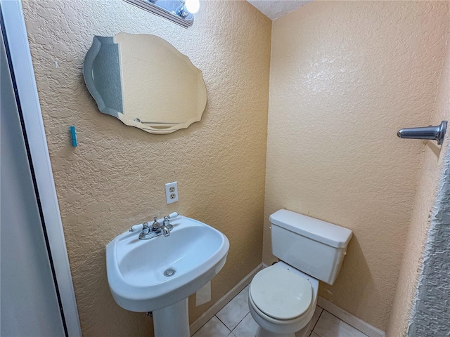 3935 SW 26th Ter Unit 3935A, Gainesville, FL 32608 - half bathroom featuring toilet, tile patterned floors, and a sink