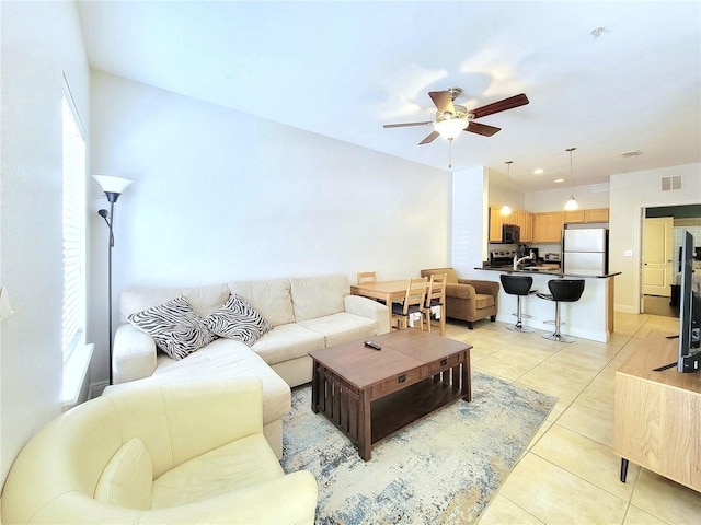 living area featuring ceiling fan and light tile patterned floors