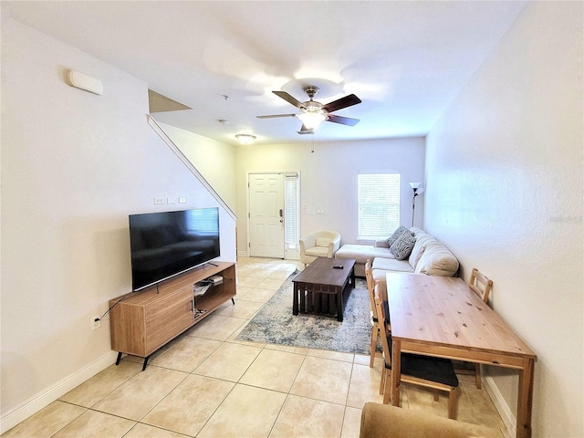 living room with ceiling fan, light tile patterned flooring, and baseboards
