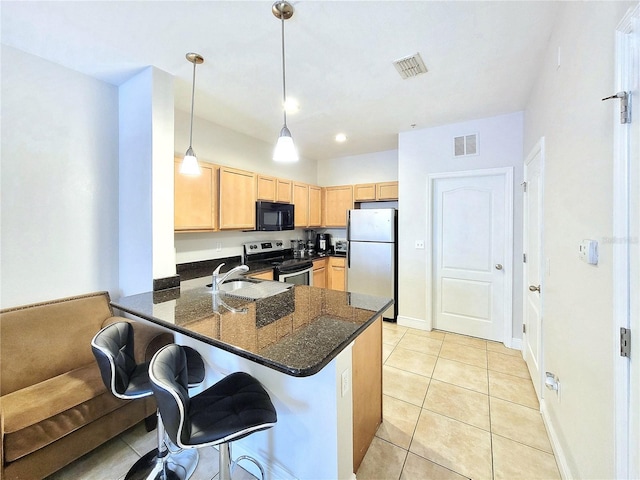 kitchen with stainless steel appliances, a peninsula, light brown cabinetry, light tile patterned floors, and a breakfast bar area