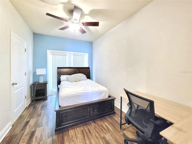 bedroom featuring wood finished floors, a desk, baseboards, and ceiling fan