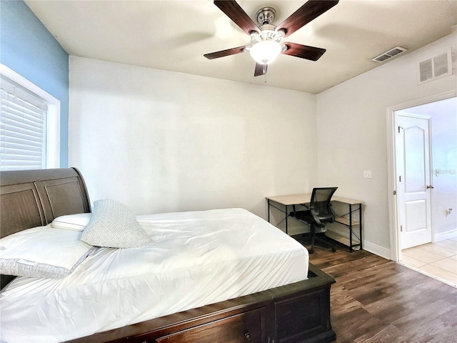 bedroom with wood finished floors, baseboards, and ceiling fan