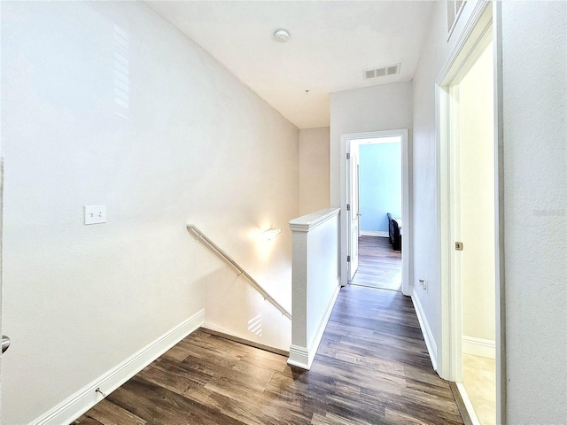 hallway featuring an upstairs landing, dark wood-style floors, and baseboards