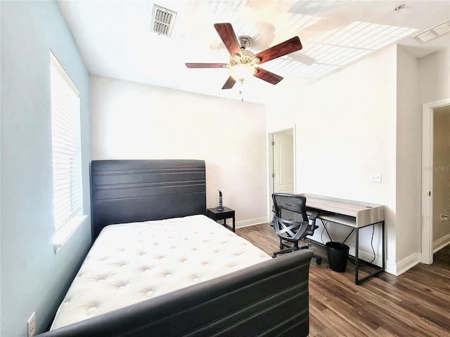 bedroom with multiple windows, wood finished floors, and baseboards
