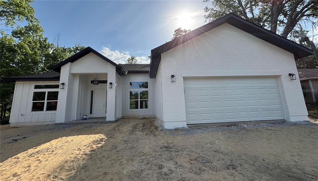 10616 NW 61st Ter, Alachua, FL 32615 - single story home featuring board and batten siding, an attached garage, and brick siding