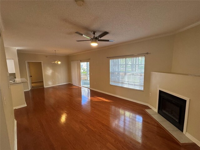 10000 SW 52nd Ave Unit 76, Gainesville, FL 32608 - unfurnished living room featuring ornamental molding, a textured ceiling, a fireplace with flush hearth, ceiling fan with notable chandelier, and wood finished floors
