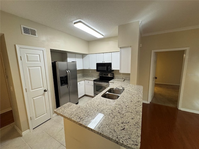 10000 SW 52nd Ave Unit 76, Gainesville, FL 32608 - kitchen featuring a peninsula, white cabinetry, visible vents, appliances with stainless steel finishes, and a sink