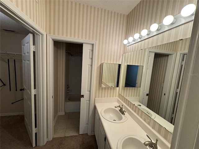 10000 SW 52nd Ave Unit 76, Gainesville, FL 32608 - bathroom with wallpapered walls, double vanity, a sink, and tub / shower combination