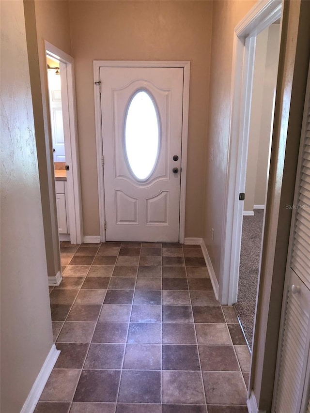 doorway featuring baseboards