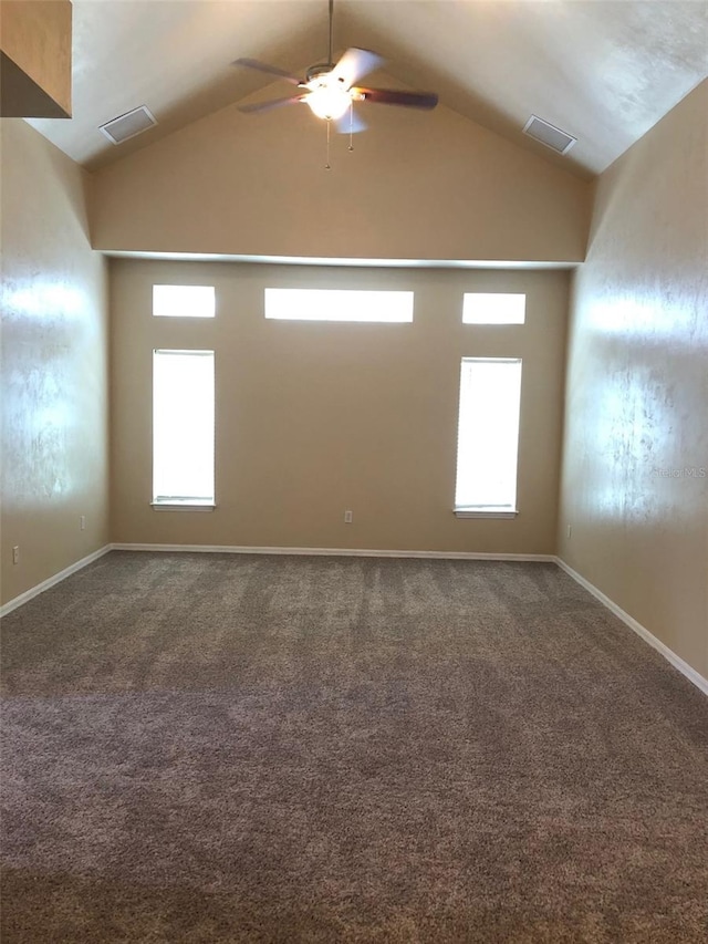 carpeted spare room featuring lofted ceiling, baseboards, a ceiling fan, and visible vents
