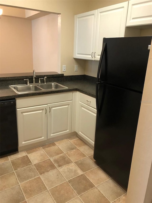 kitchen featuring white cabinets, dark countertops, black appliances, and a sink