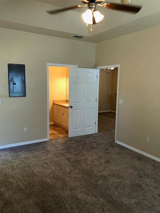 unfurnished bedroom with electric panel, carpet, visible vents, connected bathroom, and baseboards