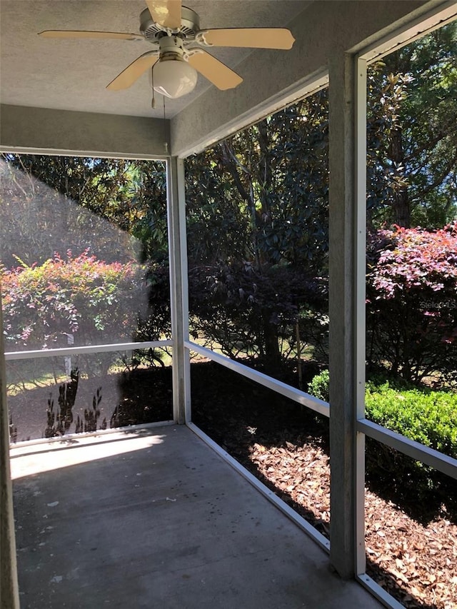 unfurnished sunroom with ceiling fan