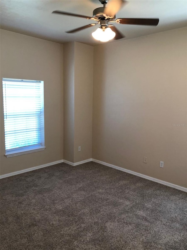 carpeted spare room with baseboards and ceiling fan