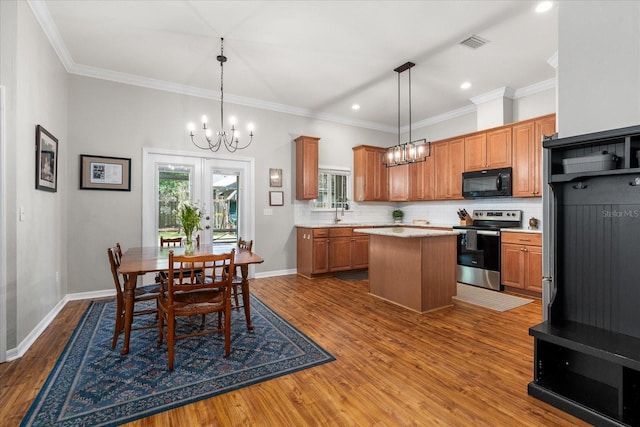 2184 NW 144th St, Newberry, FL 32669 - kitchen with light countertops, backsplash, black microwave, stainless steel electric range, and a chandelier