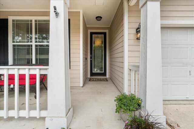 2184 NW 144th St, Newberry, FL 32669 - view of exterior entry with a garage and covered porch
