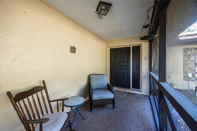 entrance to property with stucco siding and a balcony