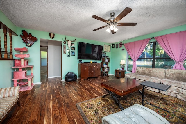 living room with wood finished floors, a textured ceiling, baseboards, and ceiling fan