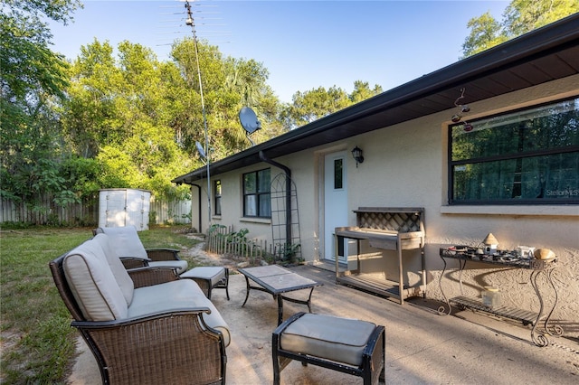 view of patio featuring outdoor lounge area and fence