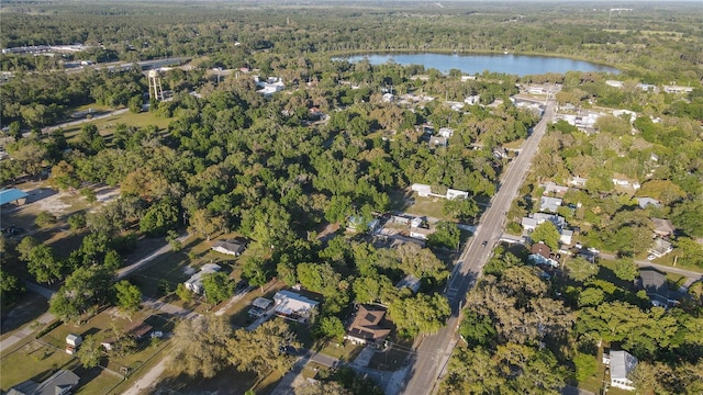 drone / aerial view with a forest view and a water view