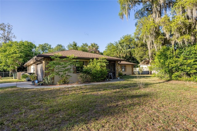 view of front facade with a front lawn, fence, and a garage