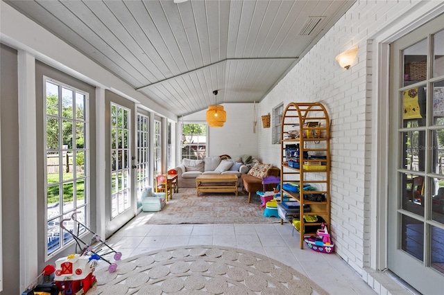 sunroom with tile patterned floors, visible vents, vaulted ceiling, and french doors