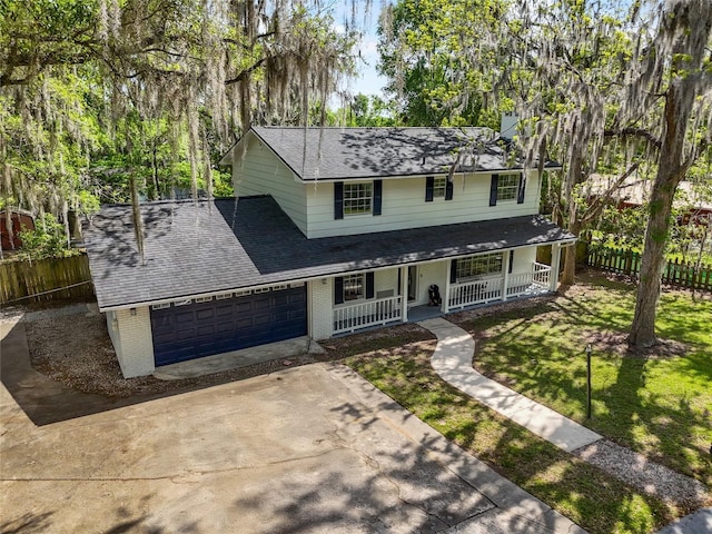 view of front of home with a shingled roof, a porch, fence, brick siding, and driveway