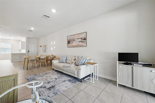 living room featuring recessed lighting, visible vents, baseboards, and light tile patterned flooring