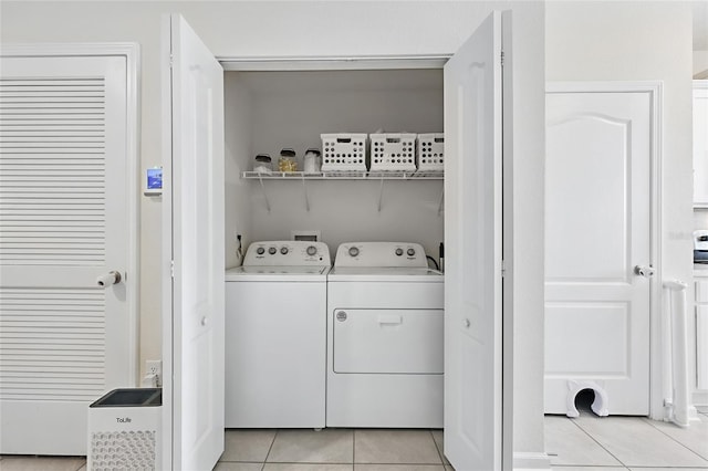 washroom featuring light tile patterned floors, washing machine and dryer, and laundry area