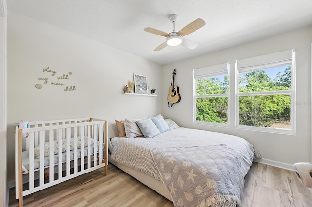 bedroom with wood finished floors, baseboards, and a ceiling fan