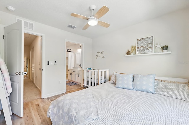 bedroom featuring visible vents, baseboards, attic access, and light wood-style flooring