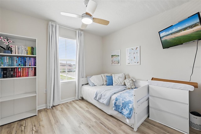 bedroom featuring baseboards, a ceiling fan, and wood finished floors