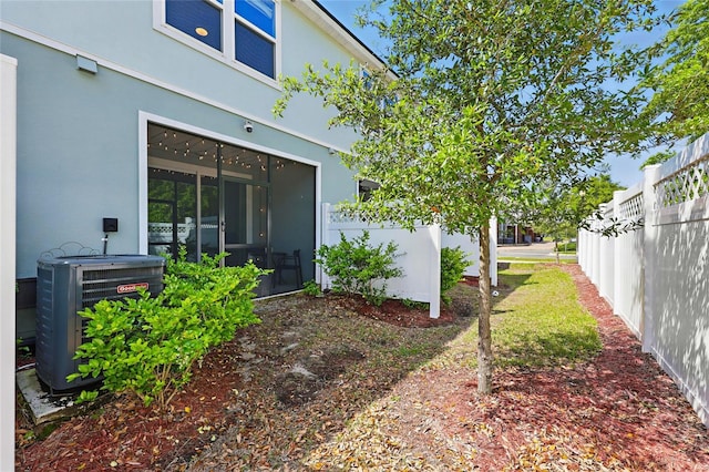 exterior space featuring central AC unit, stucco siding, and fence