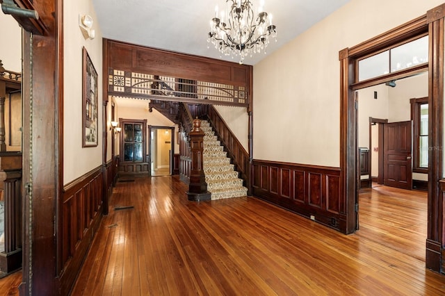 interior space with a wainscoted wall, stairway, and hardwood / wood-style flooring