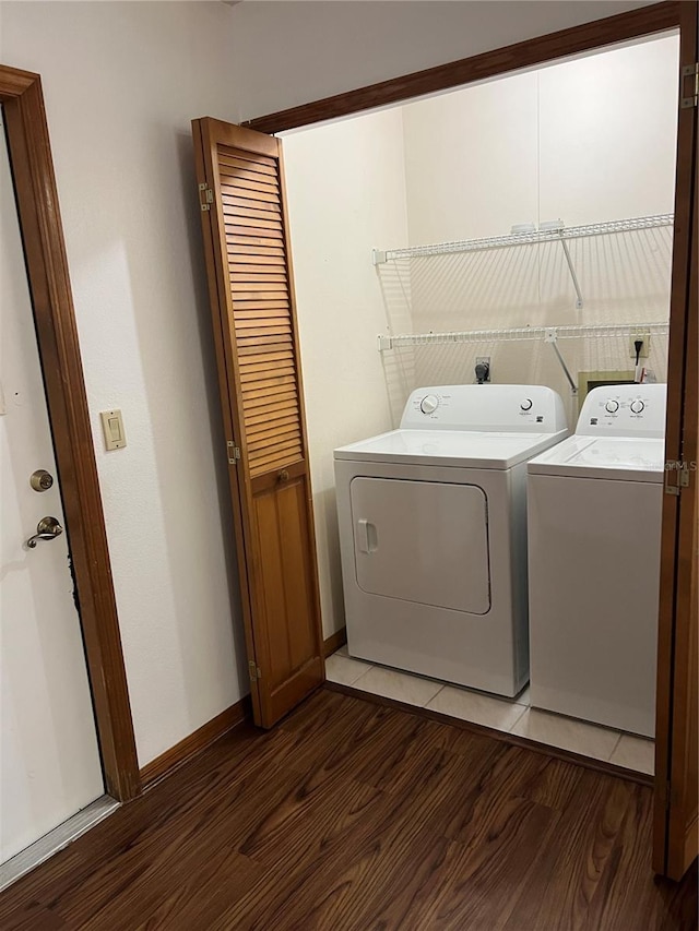 laundry room with washer and dryer, laundry area, baseboards, and wood finished floors