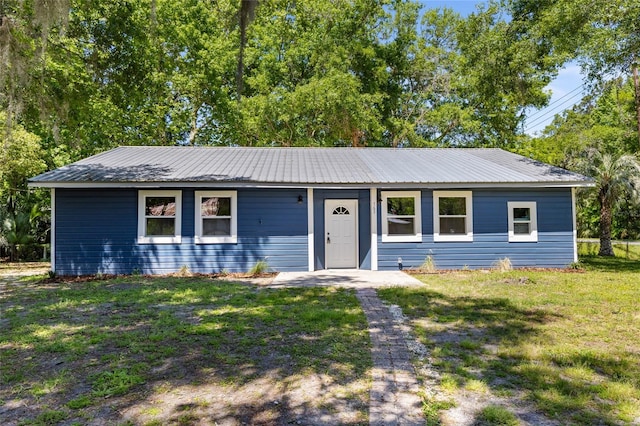 single story home featuring a front yard and metal roof
