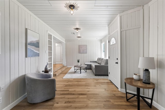 living area featuring wood walls and wood finished floors