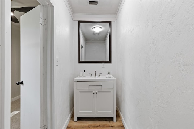 bathroom featuring baseboards, vanity, wood finished floors, and visible vents