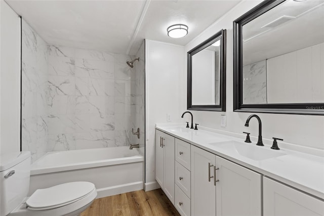 full bath with toilet, wood finished floors, a sink, and bathing tub / shower combination