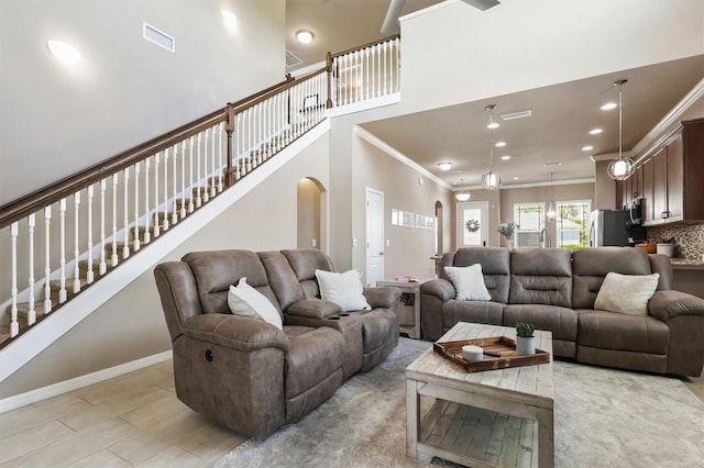 living room featuring visible vents, crown molding, arched walkways, stairs, and recessed lighting
