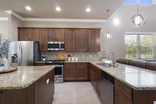 kitchen featuring crown molding, appliances with stainless steel finishes, a sink, a peninsula, and backsplash
